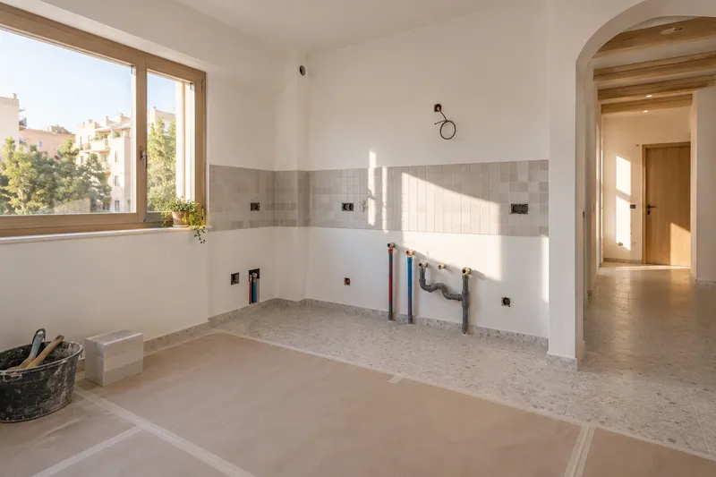 Visualización conceptual IA: Tuberías de suministro y desagüe durante la renovación de una cocina.